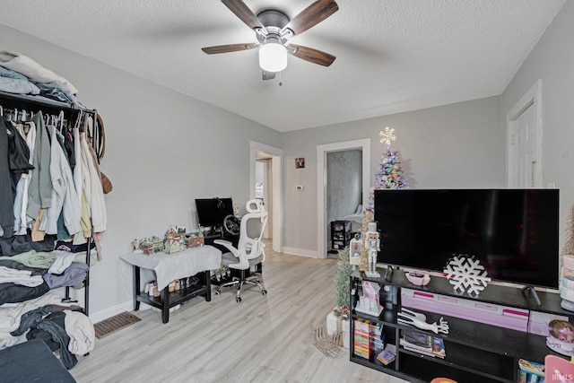 office with ceiling fan, light hardwood / wood-style floors, and a textured ceiling