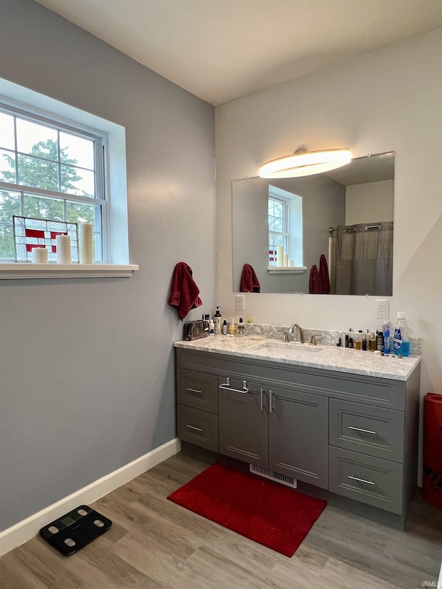 bathroom featuring wood-type flooring, vanity, and walk in shower