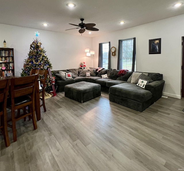 living room with light hardwood / wood-style floors and ceiling fan