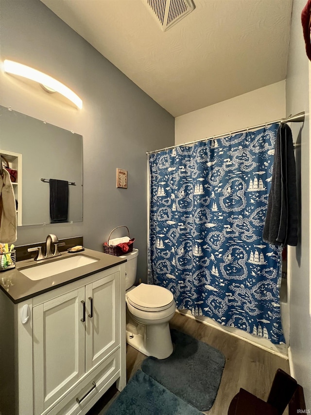 bathroom with a shower with curtain, vanity, hardwood / wood-style flooring, and toilet