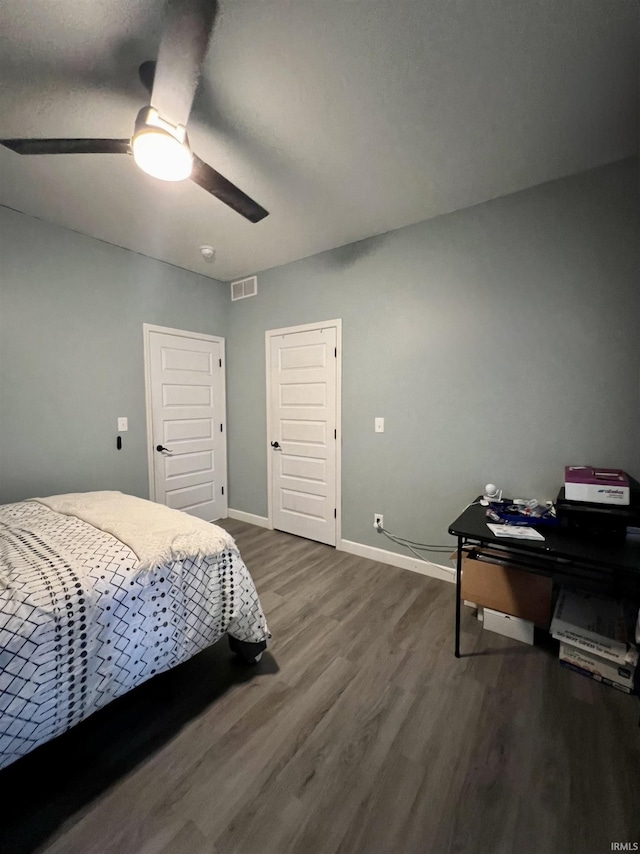 bedroom with ceiling fan and dark wood-type flooring