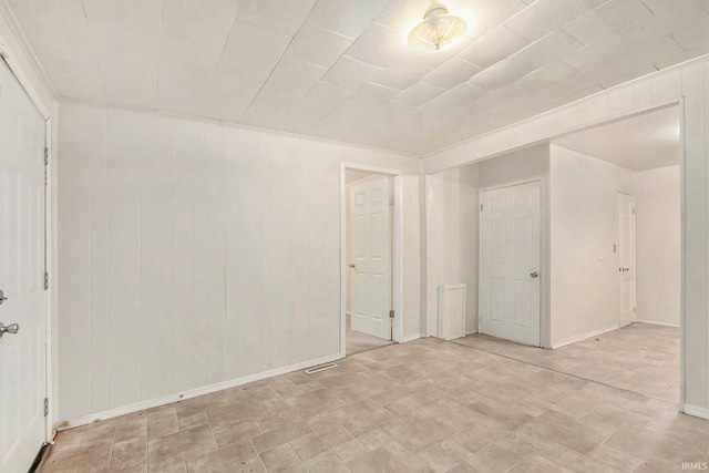 spare room featuring wood walls