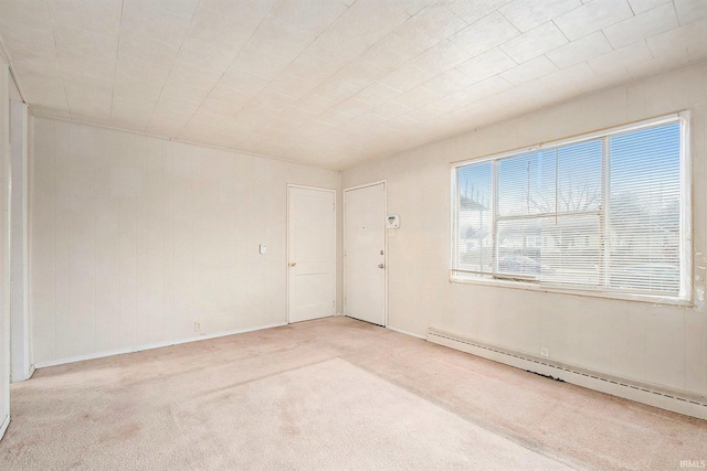 empty room with light colored carpet and a baseboard heating unit