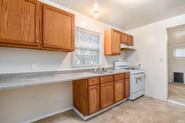 kitchen with white stove and sink