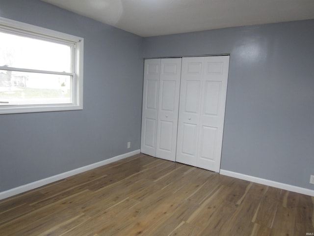 unfurnished bedroom with hardwood / wood-style flooring and a closet