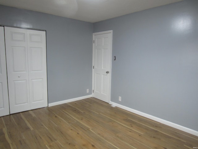 unfurnished bedroom with hardwood / wood-style floors and a closet