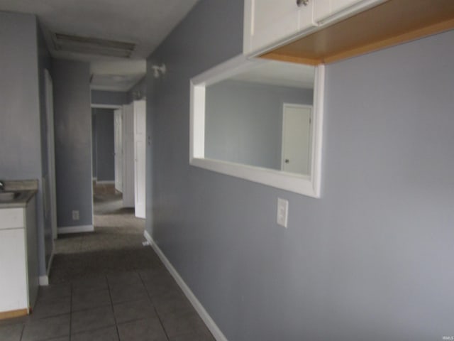 hallway with dark tile patterned flooring