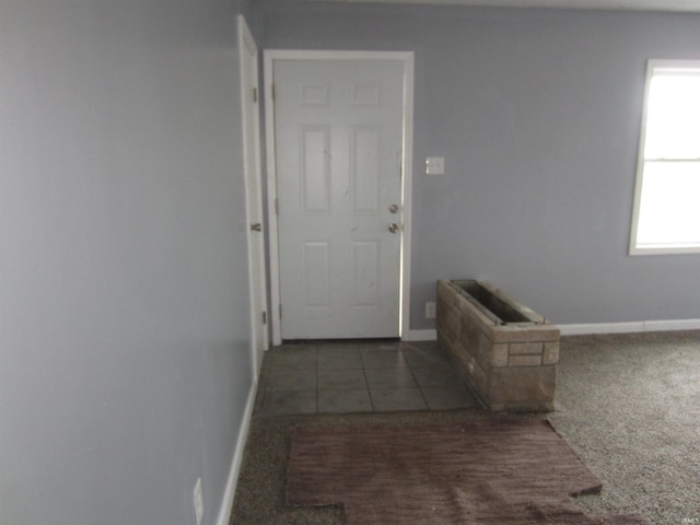 hall with dark colored carpet