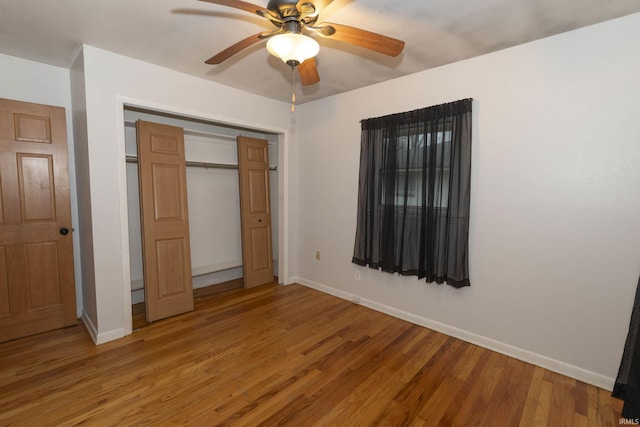 unfurnished bedroom with a closet, hardwood / wood-style flooring, and ceiling fan