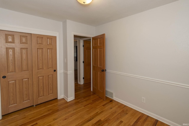 unfurnished bedroom featuring light hardwood / wood-style floors and a closet