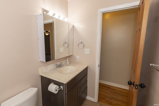 bathroom with hardwood / wood-style floors, vanity, and toilet