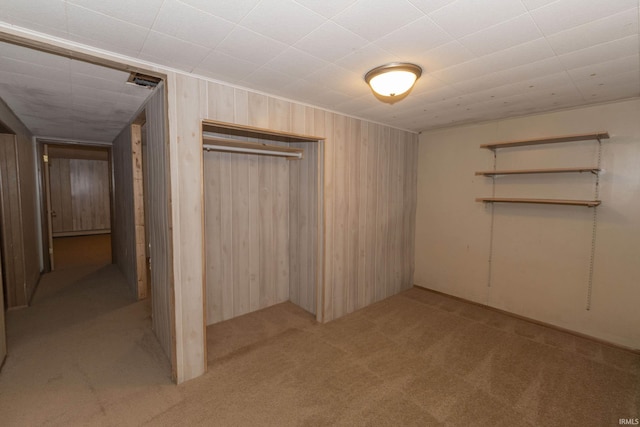 basement with light colored carpet and wooden walls