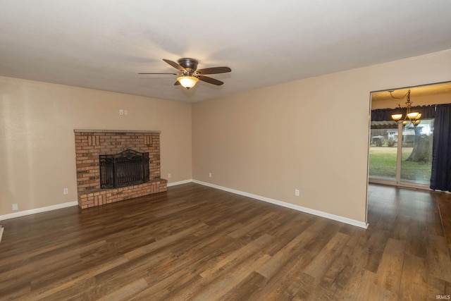 unfurnished living room featuring a fireplace, ceiling fan with notable chandelier, and dark hardwood / wood-style floors