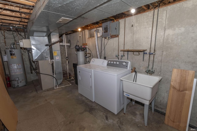 clothes washing area featuring heating unit, washer and clothes dryer, gas water heater, and electric panel