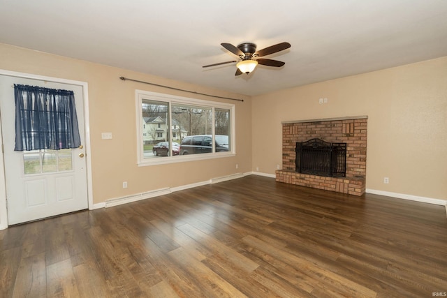 unfurnished living room with dark hardwood / wood-style flooring, baseboard heating, and a healthy amount of sunlight