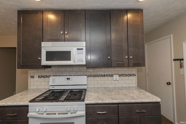 kitchen with white appliances, dark brown cabinetry, and backsplash