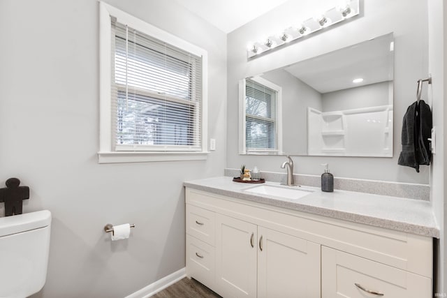 bathroom featuring hardwood / wood-style floors, vanity, toilet, and a healthy amount of sunlight