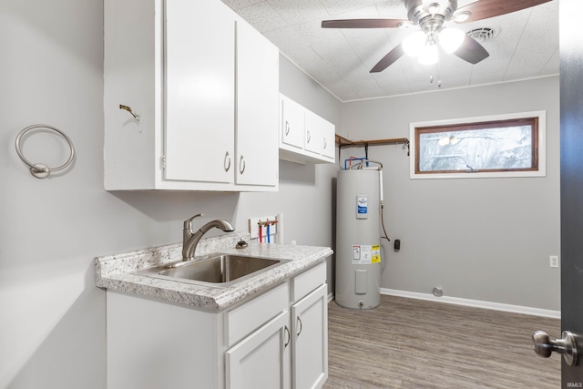 kitchen featuring ceiling fan, sink, electric water heater, light hardwood / wood-style floors, and white cabinets