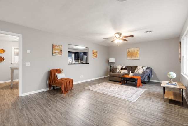 living room featuring dark hardwood / wood-style floors and ceiling fan