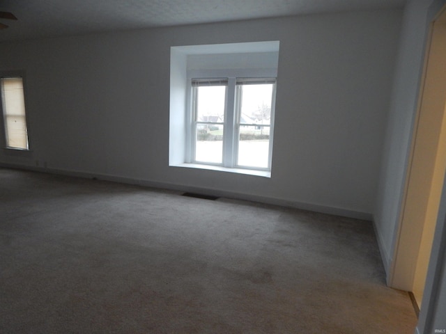 carpeted spare room featuring a textured ceiling