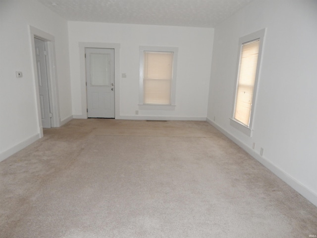 carpeted empty room with a textured ceiling