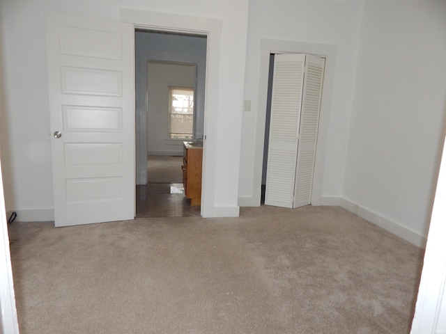 unfurnished bedroom featuring light colored carpet and a closet