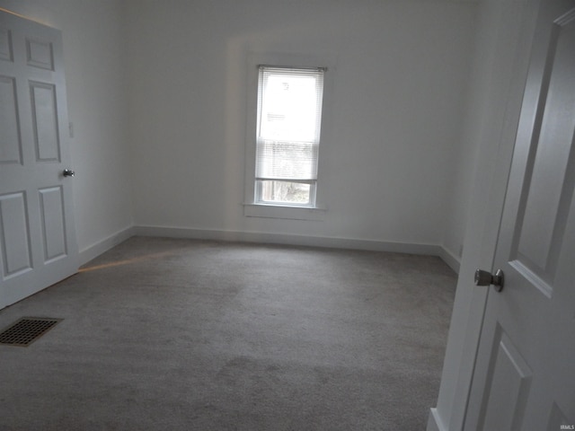 spare room featuring light carpet