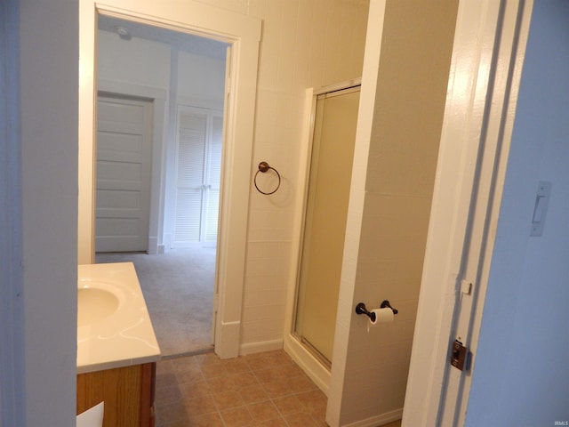 bathroom with a shower with door and vanity