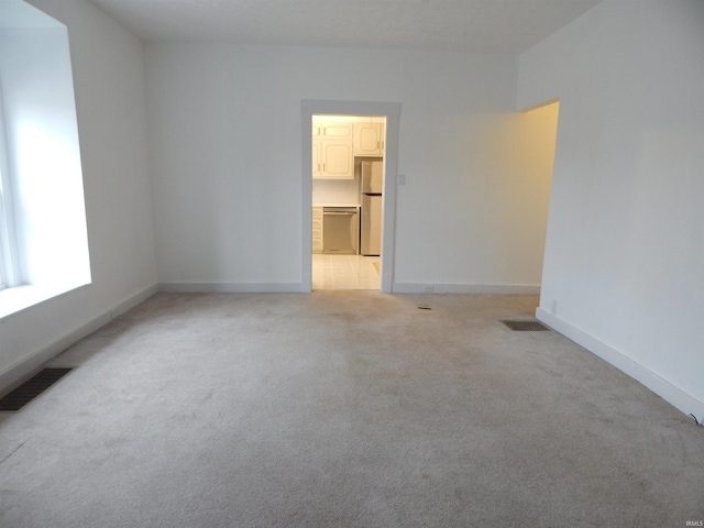 spare room featuring light colored carpet