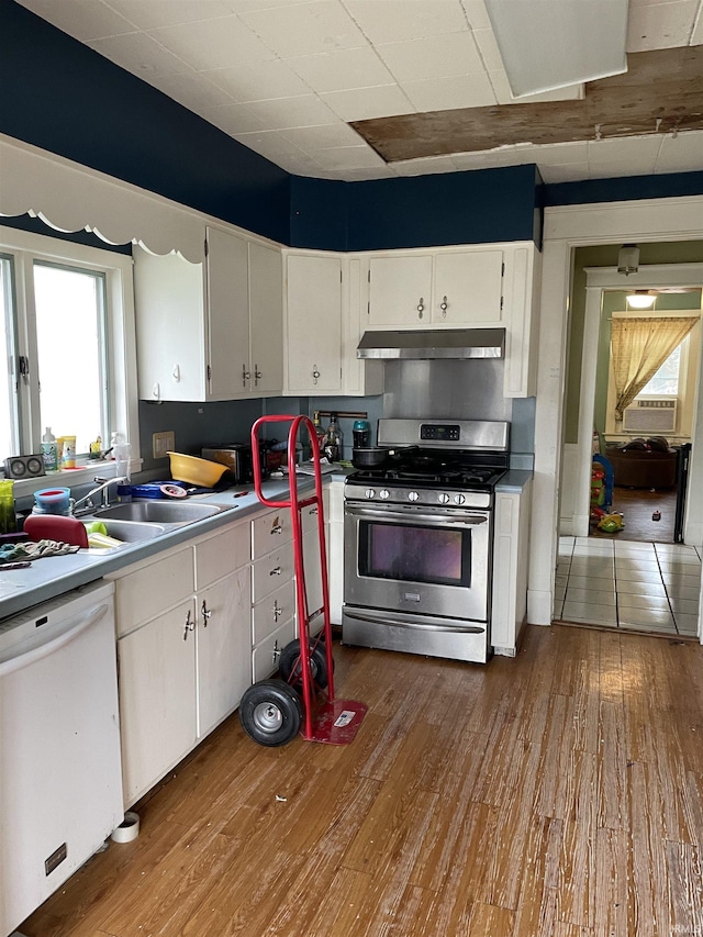 kitchen featuring white cabinets, sink, dishwasher, hardwood / wood-style floors, and stainless steel range with gas stovetop