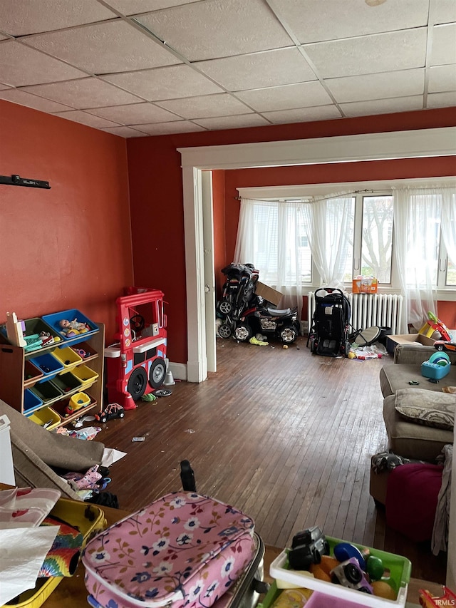 playroom with hardwood / wood-style floors and a drop ceiling