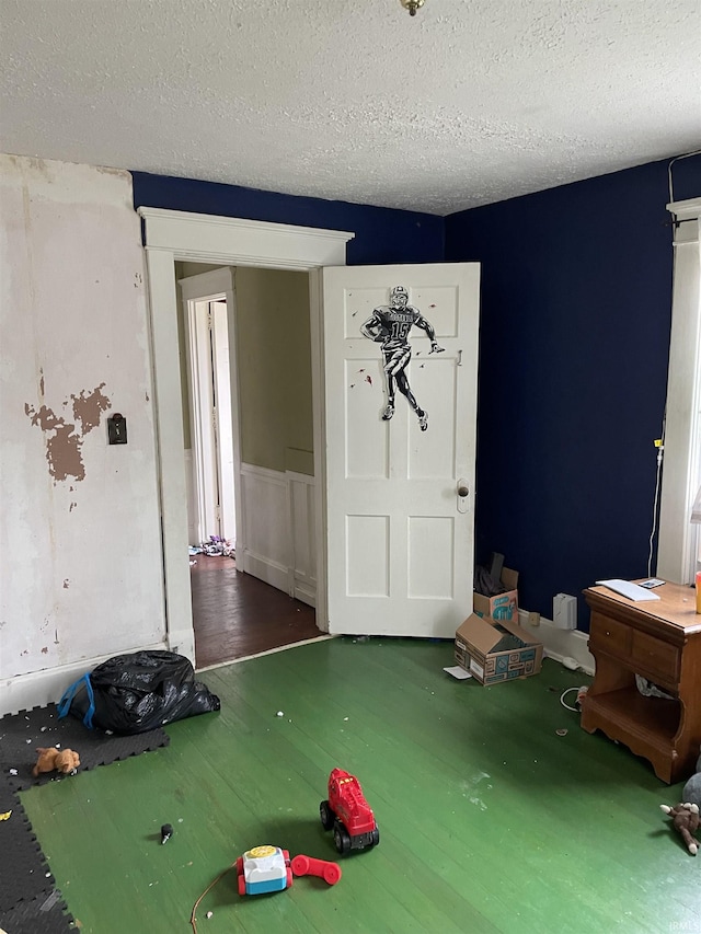 unfurnished bedroom with a textured ceiling and dark hardwood / wood-style floors