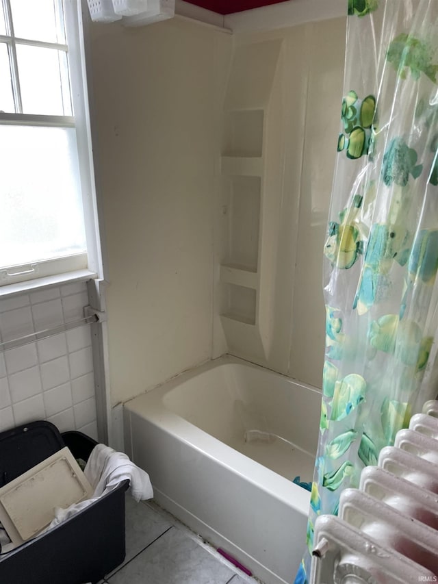 bathroom featuring tile patterned flooring, shower / bath combination with curtain, and tile walls