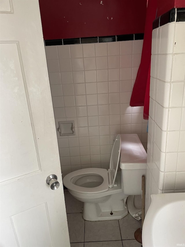 bathroom with sink, tile patterned flooring, tile walls, and toilet