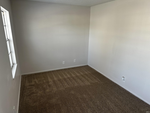 carpeted empty room featuring a textured ceiling