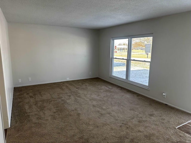 carpeted empty room featuring a textured ceiling