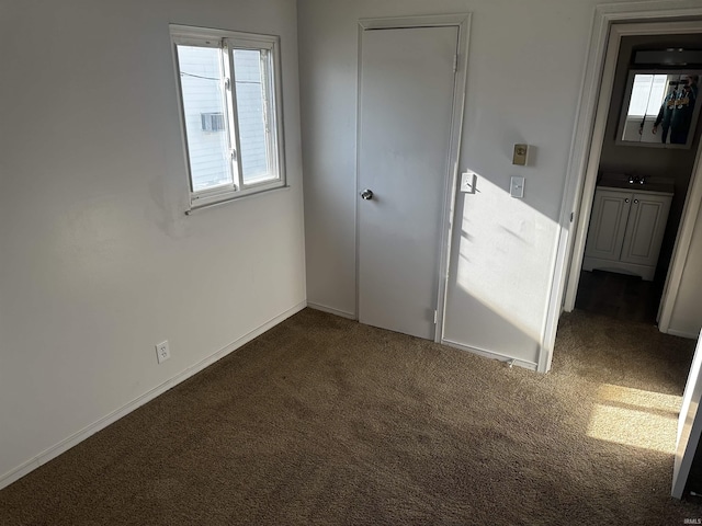 unfurnished bedroom with dark colored carpet and sink