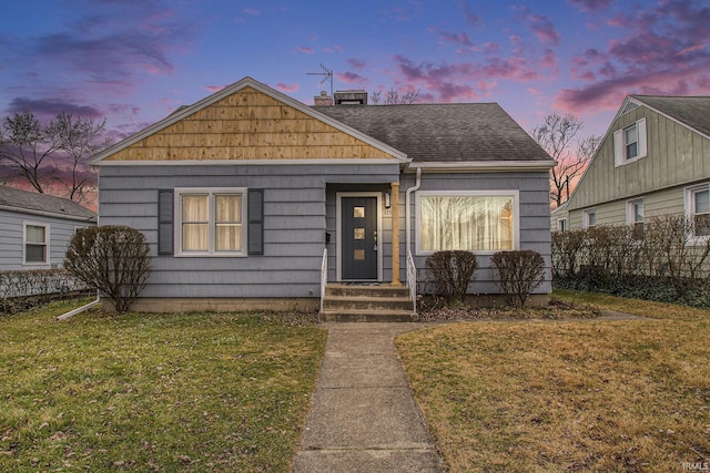 bungalow-style home with a lawn