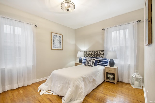 bedroom with multiple windows and hardwood / wood-style floors