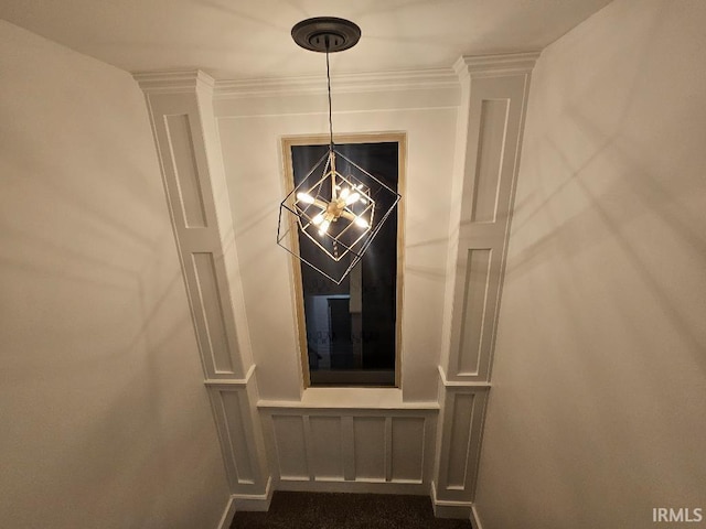 interior details with crown molding and a notable chandelier