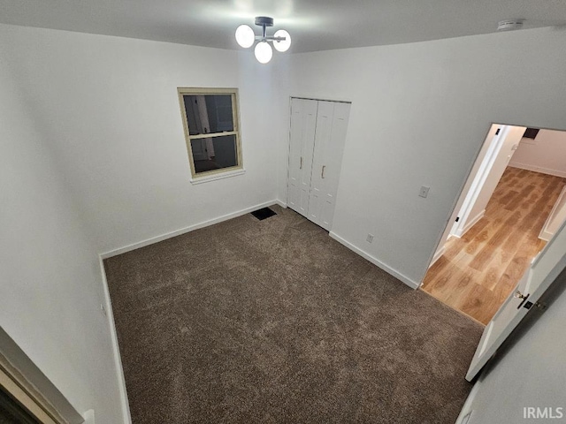 empty room featuring dark hardwood / wood-style flooring and an inviting chandelier