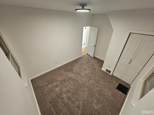 additional living space featuring dark colored carpet