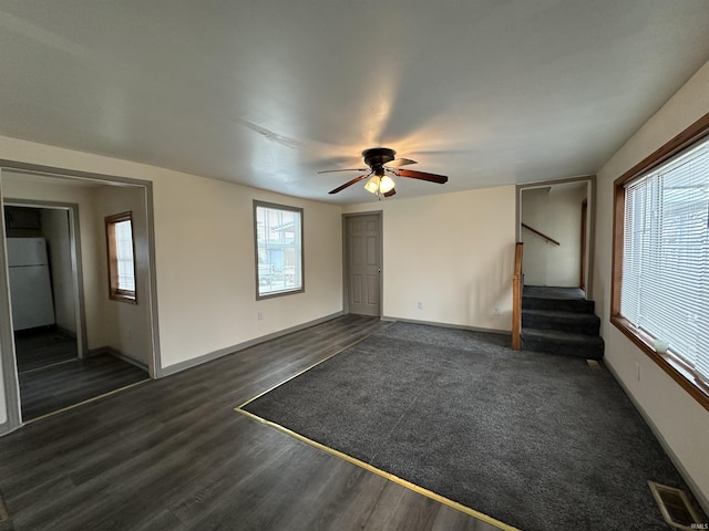 unfurnished living room featuring dark hardwood / wood-style flooring and ceiling fan