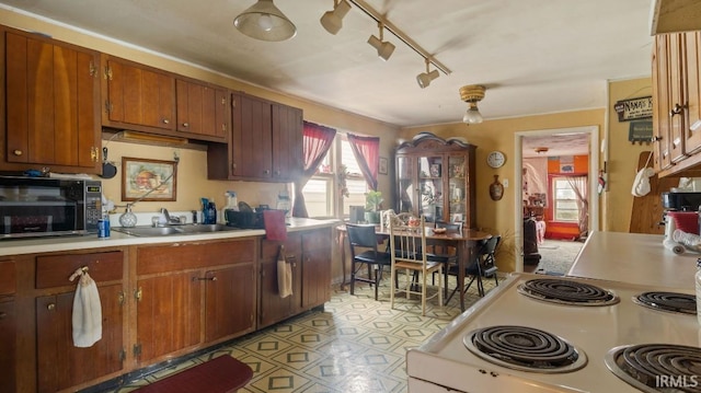 kitchen featuring rail lighting, white range oven, and sink