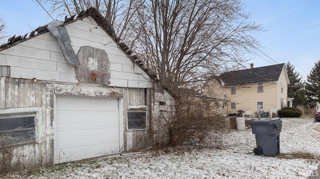 view of snow covered exterior featuring a garage