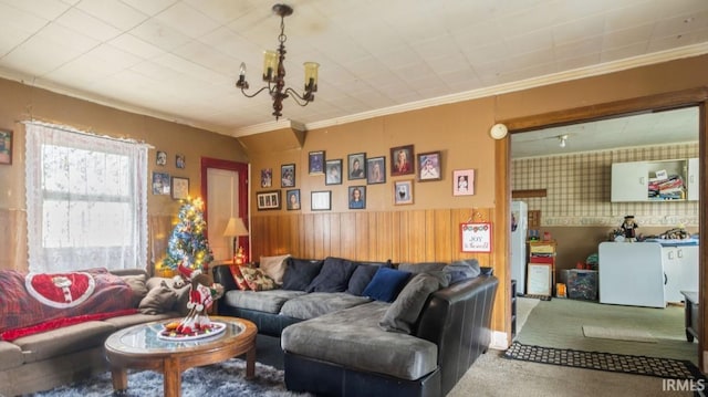 living room featuring crown molding, carpet floors, and an inviting chandelier