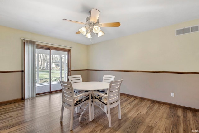 dining space with ceiling fan and wood-type flooring