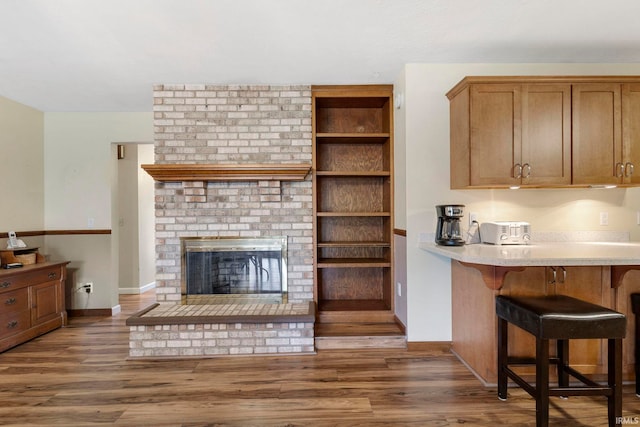 living room with dark hardwood / wood-style flooring and a brick fireplace