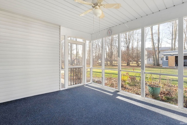 unfurnished sunroom featuring ceiling fan and a healthy amount of sunlight