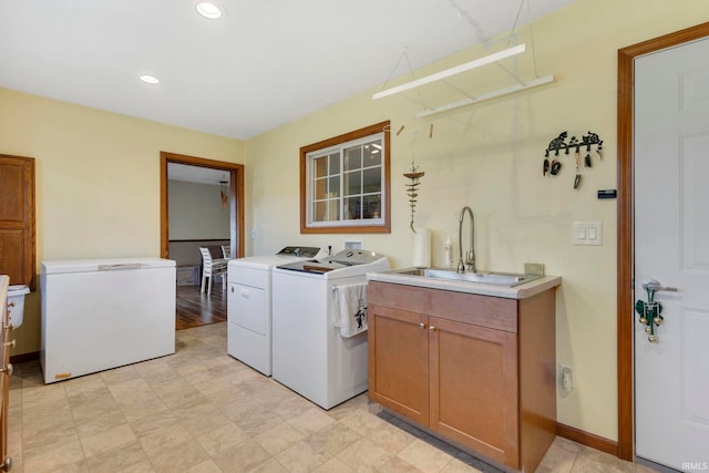 laundry area featuring sink, cabinets, and independent washer and dryer